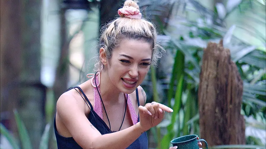 Ariel schaut verkniffen und zeigt mit dem Finger auf jemanden.