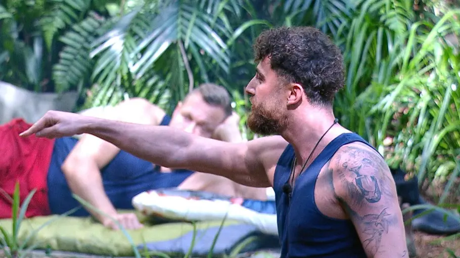 Umut Tekin zeigt wütend mit dem Zeigefinger auf etwas im Dschungelcamp