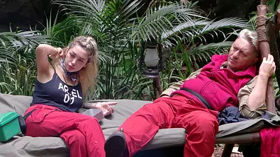 Ariel und Hubert sitzen auf einer Liege im Dschungelcamp - Foto: RTL