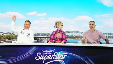 DSDS-Jury 2026 mit Dieter Bohlen, Isi Glück im pinken Outfit und Bushido am Jury-Pult vor Köln-Kulisse. - Foto: RTL / Stefan Gregorowius