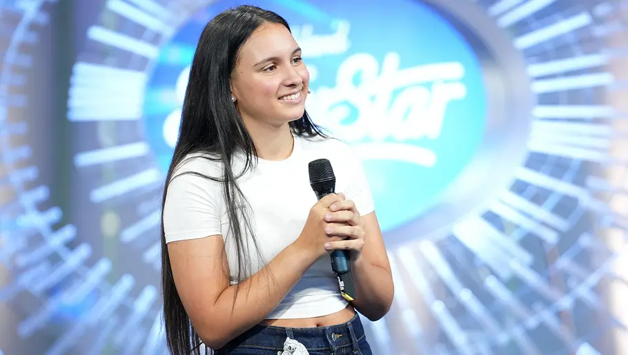DSDS Kandidatin Valentina Valentina Wagner steht beim DSDS-Casting mit einem Mikrofon in der Hand vor dem Jury-Logo und lächelt selbstbewusst in die Kamera.