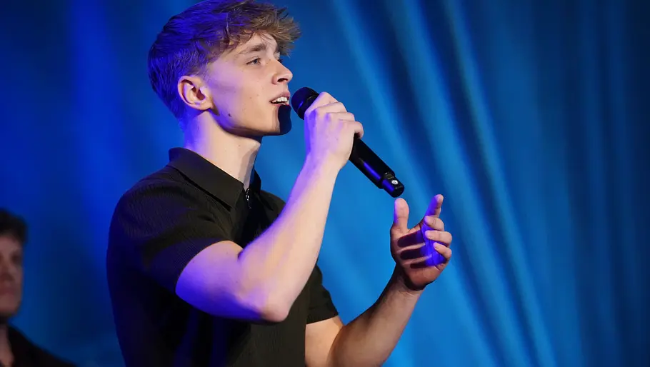 Tyrell Hagedorn Tyrell im schwarzen T‑Shirt singt ins Mikrofon und gestikuliert mit der freien Hand.