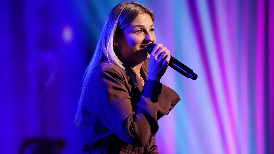 Loredana Bono Loredana mit langen blonden Haaren singt ins Mikrofon.