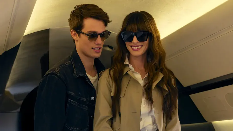 Soléne und Hayes in einem Flugzeug. Beide tragen Sonnenbrillen und lächeln.