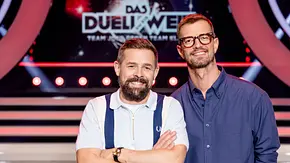  Links Klaas Heufer-Umlauf, rechts daneben Joko Winterscheidt grinsend vor dem Das Duell um die Welt-Logo - Foto: Joyn