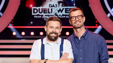 Links Klaas Heufer-Umlauf, rechts daneben Joko Winterscheidt grinsend vor dem Das Duell um die Welt-Logo - Foto: Joyn Links Klaas Heufer-Umlauf, rechts daneben Joko Winterscheidt grinsend vor dem Das Duell um die Welt-Logo - Foto: Joyn