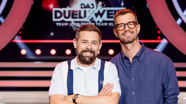  Links Klaas Heufer-Umlauf, rechts daneben Joko Winterscheidt grinsend vor dem Das Duell um die Welt-Logo - Foto: Joyn