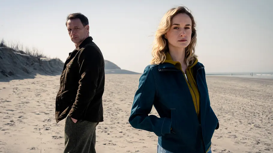Dünentod: Tödliche Falle Ermittler Tjark Wolf und Ermittlerin Femke Folkmer stehen an einem Strand.