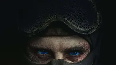 Timothée Chalamet steht als Paul Atreides in absoluter Dunkelheit und hat eine Maske über seinem Mund. Seine Augen sind blau. - Foto: Warner Bros.