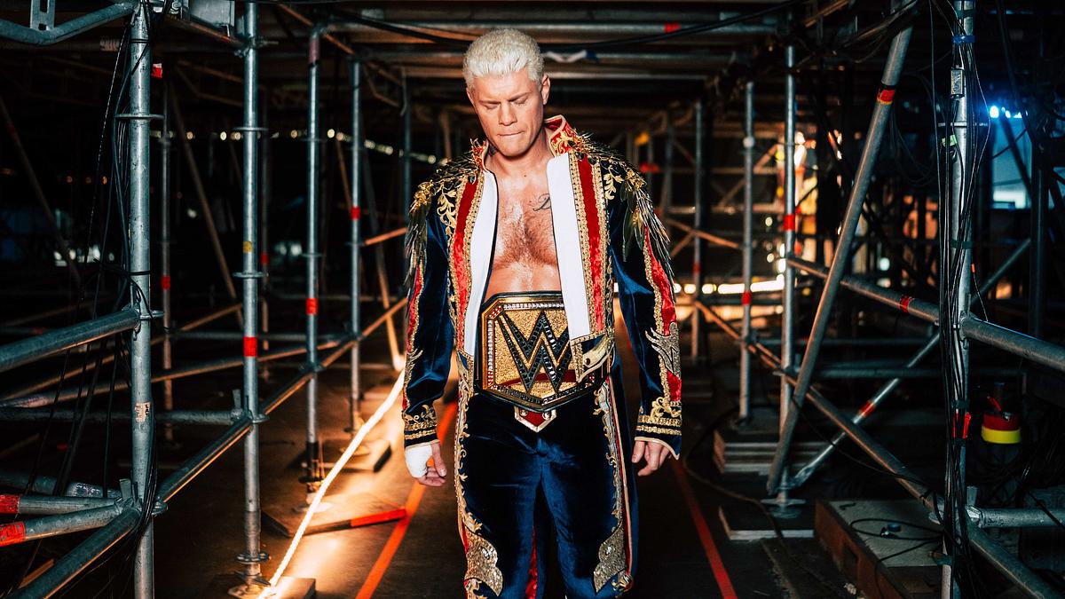 Durch den Homelander-Look von Cody Rhodes ist ein Heel-Turn eigentlich unausweichlich. Cody Rhodes geht durch einen Gang unter den Zuschauertribünen.
