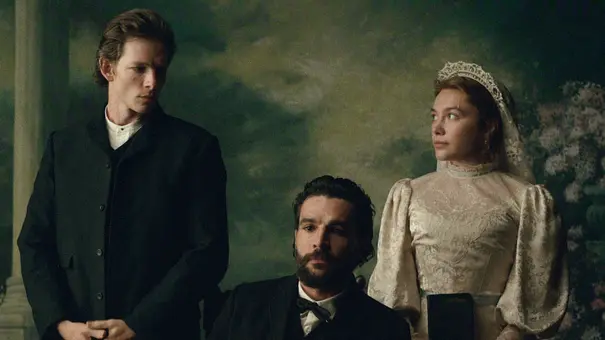Chalres steht in East of Eden im dunkle Anzug neben seinem Bruder Adam und dessen Frau Cahty, die im Brautkleid zu ihm herüberschaut. - Foto: Netflix Chalres steht in East of Eden im dunkle Anzug neben seinem Bruder Adam und dessen Frau Cahty, die im Brautkleid zu ihm herüberschaut. - Foto: Netflix