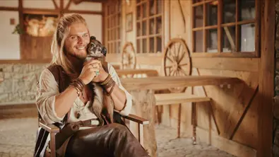 Rúrik Gíslason sitzt mit einer Hündin im Arm am Set des Films „Eat Pray Bark“. - Foto: Netflix