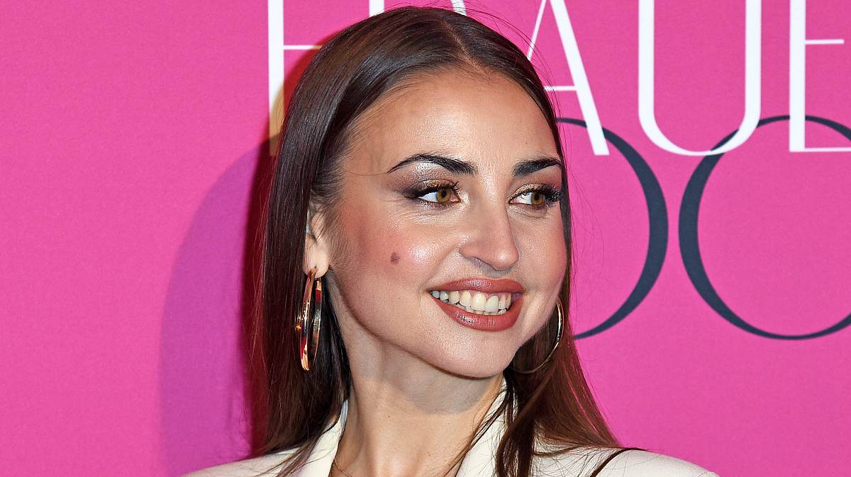 Ekat bald ohne Muttermal? Ekaterina Leonova dreht den Kopf vor pinkem Hintergrund zur Seite und gibt den Blick auf ihr ikonisches Muttermal auf der Wange frei