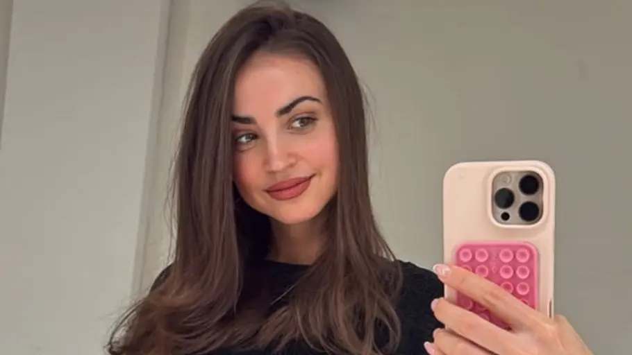 Ekaterina Leonova gibt ihren Fans ein OP-Update. Ekaterina Leonova lächelt mit Handy in der Hand.