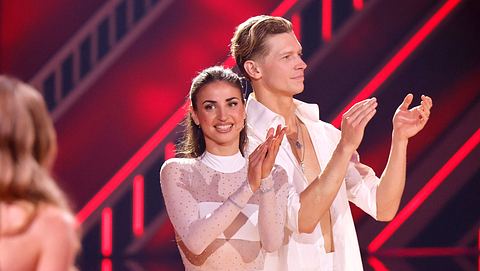 Ekaterina Leonova steht in einem durchsichtigen weißen Kleid auf der „Lets Dance“-Bühne, Victoria Swarovski stehen mit dem Rücken zur Kamera - Foto: IMAGO / Panama Pictures
