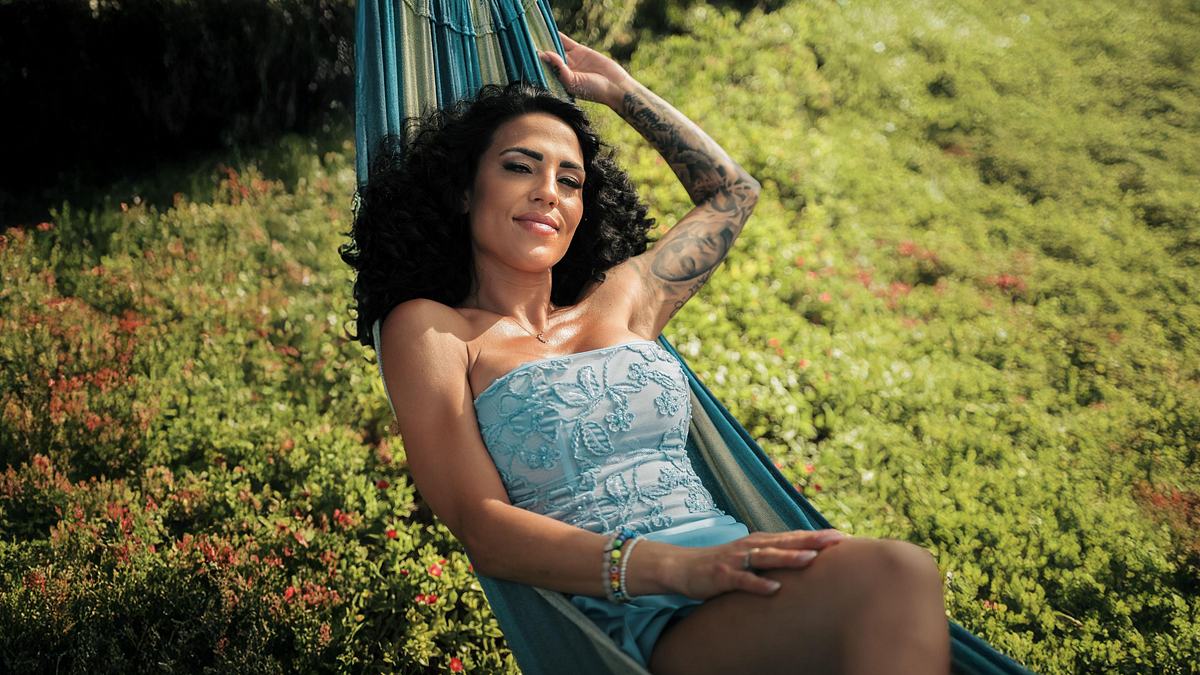 Elena Miras ist die neue Single-Lady von MLFL. Elena Miras in einem blauen Kleid in einer Hängematte auf einem Promofoto zu MLFL.