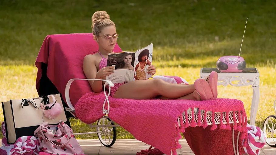 Ein Szenenbild zu „Elle“ zeigt die titelgebende Protagonistin in Pink auf einer Liege.