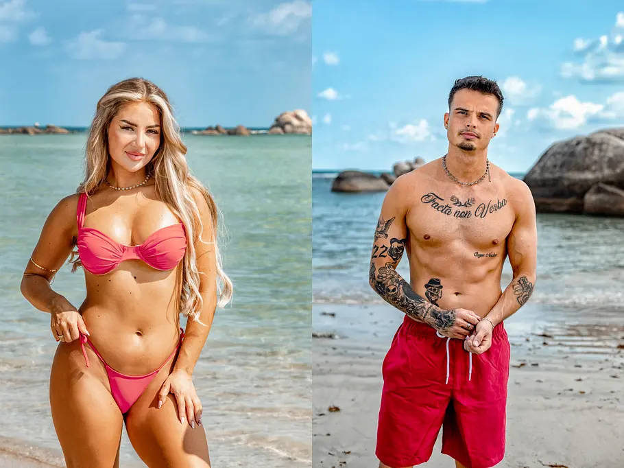AYTO Eine junge Frau im pinken Bikini und ein junger, tätowierter Mann in roter Badehose stehen jeweils am Strand vor türkisblauem Wasser und Felsen. Beide blicken lächelnd bzw. entspannt in die Kamera, im Hintergrund sind Meer und Himmel zu sehen.