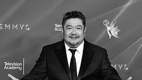 Eric Bauza posiert im dunklen Anzug mit ausgebreiteten Armen vor einer Emmy-Logowand. Die Aufnahme ist schwarz-weiß. - Foto: IMAGO / AFF-USA Eric Bauza posiert im dunklen Anzug mit ausgebreiteten Armen vor einer Emmy-Logowand. Die Aufnahme ist schwarz-weiß. - Foto: IMAGO / AFF-USA