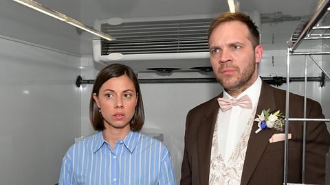 Matilda im blau-weißen Hemd und Erik im Anzug sind eingeschlossenen in einem Kühllaster. - Foto: RTL Rolf Baumgartner