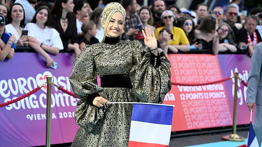 ESC 2026 Monroe Monroe posiert mit der Flagge Frankreichs auf dem Roten Teppich.