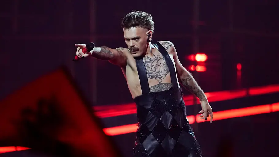 ESC 2026 Jonas Lovv Jonas Lovv steht in Latzhose aus Leder auf der Bühne und zeigt auf jemanden.