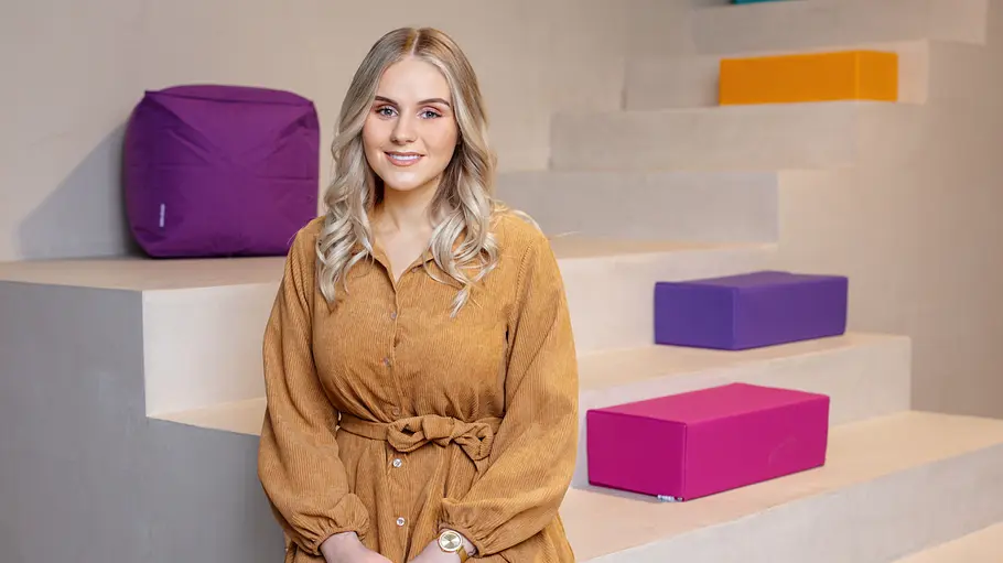 Estefania Wollny Estefania Wollny sitzt auf einer Treppe mit bunten Elementen.