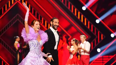 Esther Schweins hebt den Arm, Massimo lacht neben ihr. - Foto: RTL / Stefan Gregorowius