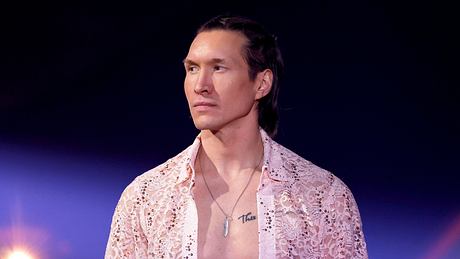Evgeny Vinokurov steht mit offenem Hemd und ernster Miene auf der Lets Dance-Bühne. - Foto: IMAGO / Panama Pictures