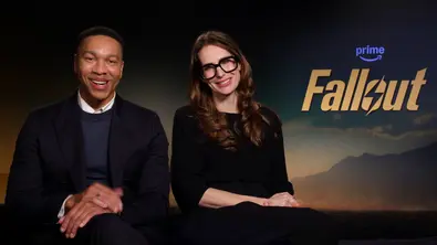 Aaron Mooten und Geneva Robertson-Dworet sitzen vor einem Fallout-Logo für ein Interview zur Serie - Foto: Prime Video / TVMovie