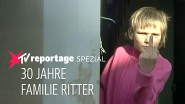 Ein Kind steht in einem Hauseingang und zeigt eine provokante Geste in Richtung Kamera. Im Bild eingeblendet ist der Schriftzug „stern TV Reportage Spezial – 30 Jahre Familie Ritter“. - Foto: RTL (DE) Ein Kind steht in einem Hauseingang und zeigt eine provokante Geste in Richtung Kamera. Im Bild eingeblendet ist der Schriftzug „stern TV Reportage Spezial – 30 Jahre Familie Ritter“. - Foto: RTL (DE)