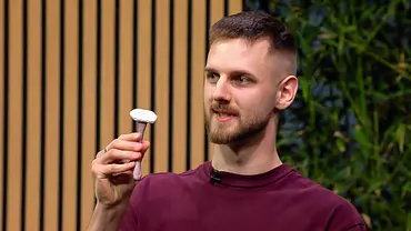 Ivo Lovric trägt ein bordeauxrotes Shirt und hält einen Rasierer hoch. Hinter ihm sind Holzlamellen und grüne Pflanzen zu sehen. - Foto: RTL Ivo Lovric trägt ein bordeauxrotes Shirt und hält einen Rasierer hoch. Hinter ihm sind Holzlamellen und grüne Pflanzen zu sehen. - Foto: RTL