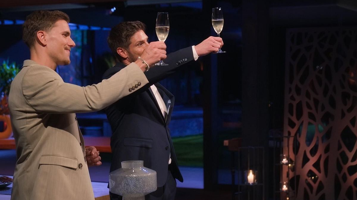 Martin Braun und Felix Stein bei der Rosenvergabe. In den Händen halten sie jeweils ein Sekt-Glas und stoßen an.