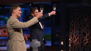 Martin Braun und Felix Stein bei der Rosenvergabe. In den Händen halten sie jeweils ein Sekt-Glas und stoßen an. - Foto: RTL+
