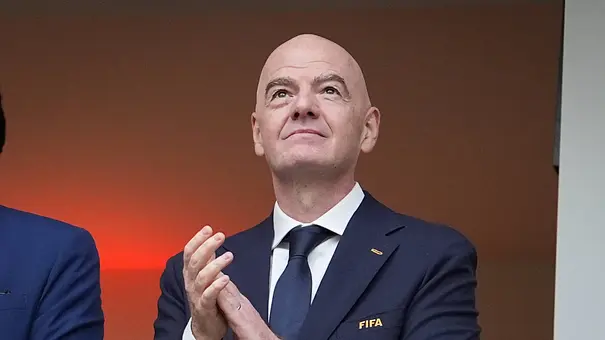FIFA-Präsident Gianni Infantino im dunklen Anzug blickt nach oben und applaudiert. - Foto: IMAGO / STEINSIEK.CH FIFA-Präsident Gianni Infantino im dunklen Anzug blickt nach oben und applaudiert. - Foto: IMAGO / STEINSIEK.CH