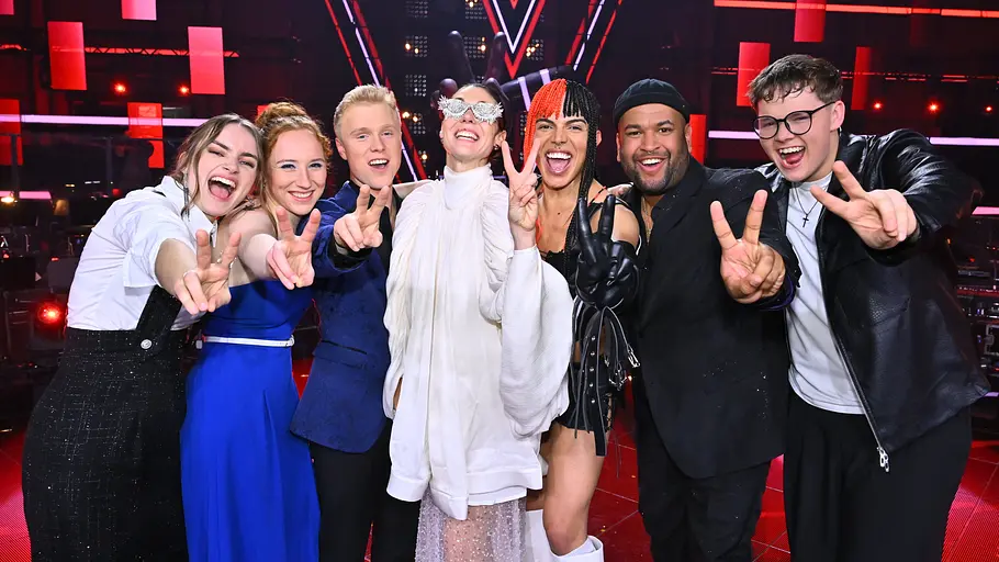 Finalisten The Voice of Germany 2025 Finalisten von The Voice of Germany 2025 von links nach rechts: Anne Mosters, Greta Heimann, Max Pesé, Bernarda Brunovic, Oxa, Vaco José Mano, Marvin Tapper auf der Bühne. Sie zeigen alle das Peace-Zeichen.
