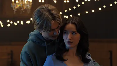Brayden steht hinter Adriana. Während er völlig entspannt wirkt, schaut sie ihn verwirrt an.  - Foto: COURTESY OF NETFLIX