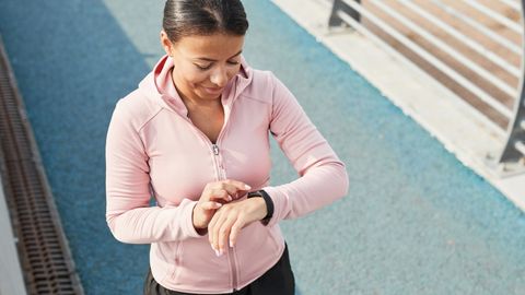 Eine junge Frau in Sportkleidung schaut auf ihre Uhr.  - Foto: TVM/PR