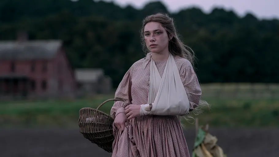 Florence Pugh spielt Cathy in „East of Eden“. Florence Pugh als Cathy im langen Kleid mit einem Arm in einer Schlinge trägt einen Weidenkorb. Hinter ihr stehen ein Haus und Bäume.