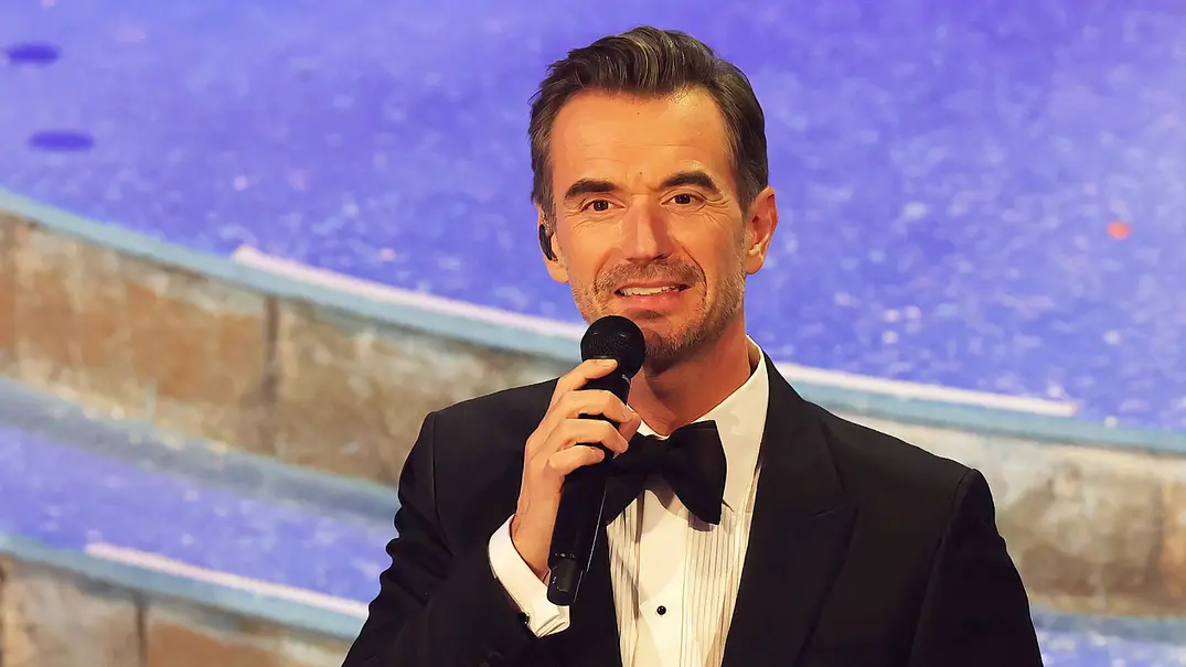Florian Silbereisen mit Mikrofon vor dem Mund in einer TV-Show. - Foto: IMAGO / Bildagentur Monn