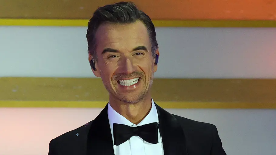 Florian Silbereisen Florian Silbereisen strahlt im schwarzen Anzug in die Kamera.