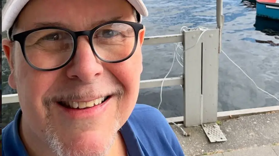 Frank Schambor wurde als „Morgenmän Franky“ bekannt. Frank Schambor lächelt mit Brille in die Kamera.
