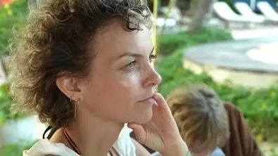 Franziska Schmidt mit lockigem Haar blickt nach rechts und hält eine Hand an ihr Gesicht. Im Hintergrund ist eine weitere Person. - Foto: RTL Franziska Schmidt mit lockigem Haar blickt nach rechts und hält eine Hand an ihr Gesicht. Im Hintergrund ist eine weitere Person. - Foto: RTL