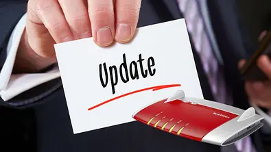 Eine Hand hält einen Zettel mit dem Wort Update. Daneben eine ältere Fritzbox - Foto: Amazon/PR/Canva