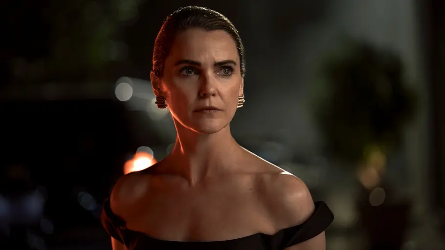 Für Kate dürfte in Staffel 5 alles anders werden. Keri Russell als Kate Wyler trägt ein schwarzes, schulterfreies Kleid und goldene Ohrringe. Sie blickt ernst zur Seite.