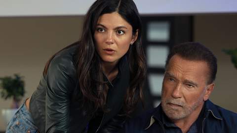 Luke sitzt, Emma beugt sich von der Seite leicht über ihn. Beide schauen nach vorne. - Foto: CHRISTOS KALOHORIDIS/NETFLIX