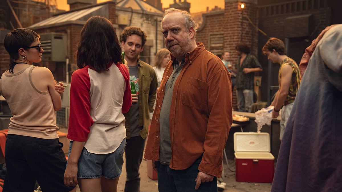 Für seinen Auftritt in der 7. Staffel könnte Paul Giamatti mit einem Emmy ausgezeichnet werden. Paul Giamatti steht etwas übellaunig zwischen jungen Leuten auf einer Dachparty.