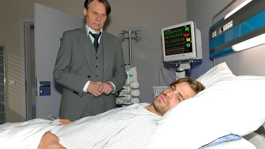 Gerner schaut Julian, der im Krankenbett liegt, ernst an.