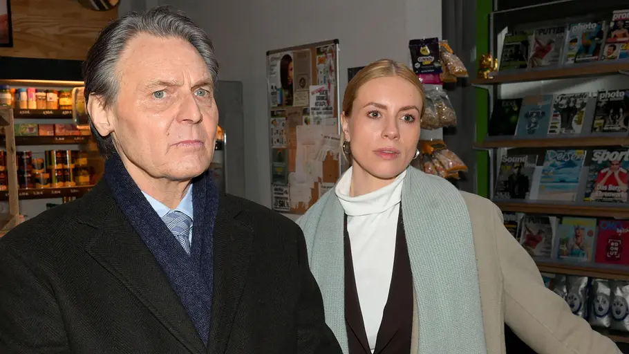 Gerner will Zoe zu Fall bringen. John schaut ernst, hinter ihm Zoe.