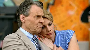 Yvonne im blau-weiß gestreiften Oberteil lehnt ihren Kopf an Gerners Schulter. Er trägt einen beigen Anzug und blickt ernst. - Foto: RTL Yvonne im blau-weiß gestreiften Oberteil lehnt ihren Kopf an Gerners Schulter. Er trägt einen beigen Anzug und blickt ernst. - Foto: RTL